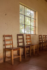 Old wooden chairs by the window at a community centre