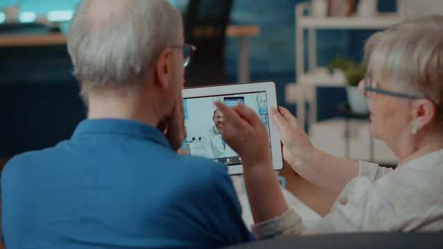 Elder patients with toothache using videocall to talk to dentist on digital tablet. Senior people calling orthodontist on remote teleconference to chat about dental care, holding gadget.