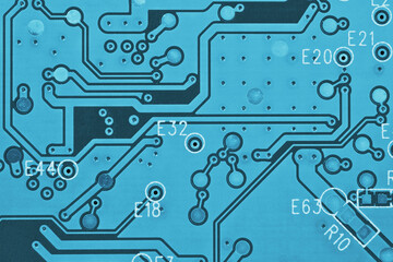 Hard drive printed circuit board PCB. Fragment of printed wiring board PWB closeup. Conductive patterns. Background about computer hardware and equipment. Light blue tinted wallpaper. Strong macro