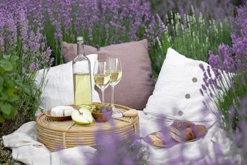 Fotobehang Glass of white wine in a lavender field. Violet flowers on the background. © Kotkoa