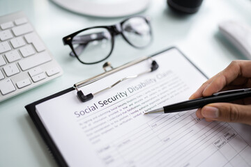 Person's Hand Filling Social Security Benefits Application