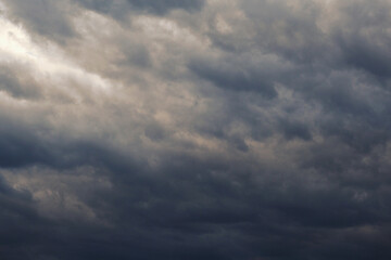 Dark gray heavy clouds in the sky before a thunderstorm. Dramatic spectacular backdrop or wallpaper. Natural grim menacing background. Ahead of a storm or cataclysm. Beastly nasty weather. Overcast