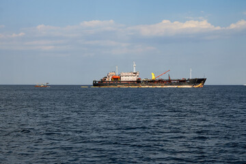 Fototapeta premium Large vessel carries goods and other cargo, it has a lifting crane and antennas for communication.