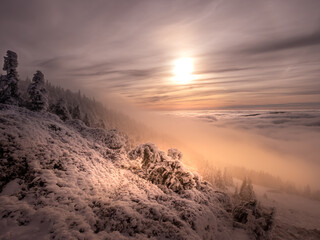 Scenic landscape with a view from a mounatin range to the valley filled with low clouds and fog...