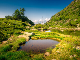Fototapeta premium Scenic mountain landscape with mountain lake,mountain peaks,stones,trees,blue sky.Summer landscape,watter. Blue. Schladminger tauern,Alps,Austria. .