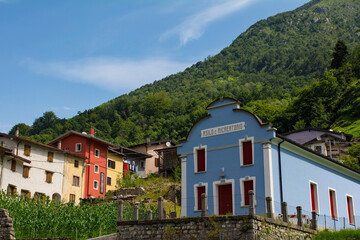 Fototapeta na wymiar The village of Dordolla in the Moggio Udinese municipality of Udine province, Friuli-Venezia Giulia, north east Italy. The text on the foreground building indicates that it is a nursery school and pla