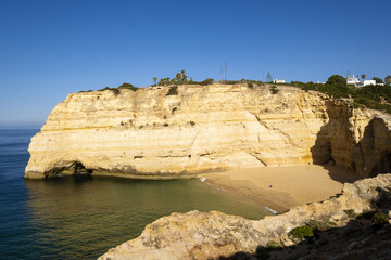 yellow cliff, sand and clear water at the Carvalho beach, Algarve, Portugal