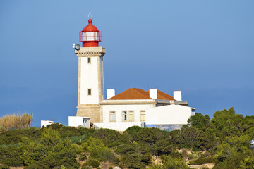 cliff and Beautiful Alfanzina Lighthouse in the coastal area of the Carvalho beach, Algarve, Portugal