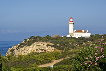 Fototapeta na wymiar cliff and Beautiful Alfanzina Lighthouse in the coastal area of the Carvalho beach, Algarve, Portugal