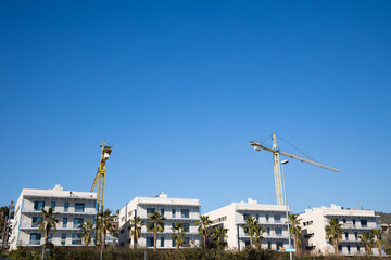 New homes construction in Spain, crane building new house, new street in Sitges with palms, real...