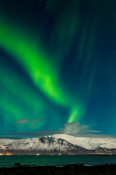 Aurora Borealis displaying over the snowcapped Mount Esja near Reykjav&iacute;k, Iceland