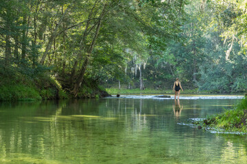 Mature woman wading where Poe Springs run meets the Santa Fe River, Gilchrist County, Florida