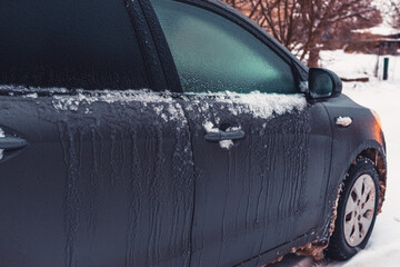 car covered with snow and icicles in winter