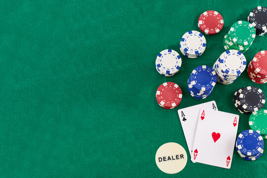 pair of aces and poker chips on green background whit copy space