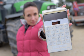 portrait of a tractor seller holding a calculator