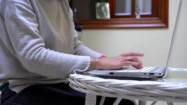 Crop woman turning off her laptop and phone after working from home.