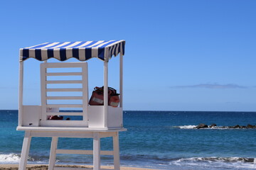 White wooden lifeguard tower at the beach on a sunny day at paradies 