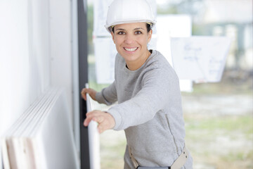 woman builder with work helmet holds white boards