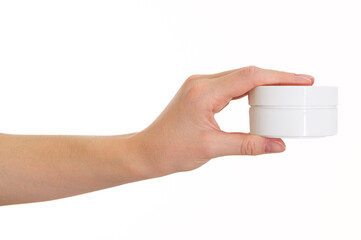 The girl holds a white jar of cream on a white background