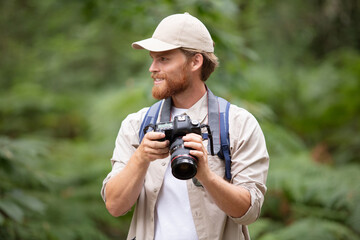 Fototapeta premium portrait of a nature photographer walking in the forest