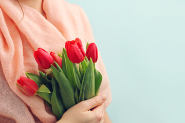 female hands with tulips. a bouquet of red tulips in the hands of a girl. Close up image of beautiful tulips bouquet in hand. Online order from a flower shop. International Women's Day. Banner, flyer,