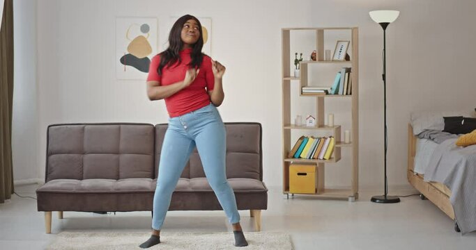 Black positive woman dancing at home