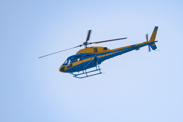 Fototapeta na wymiar Yellow and blue Helicopter of Traffic surveillance Patrolling the roads and highways to control reckless driving.