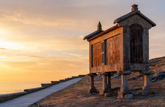 typical Galician granary beside the sea at sunset in Baiona, Galicia, Spain.