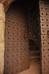 old metal door. metal door with rivets at the entrance to a fortress. detail. photo during the day.