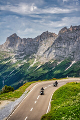 two motorcyclists touring the mountains of the Swiss Alps in Switzerland.