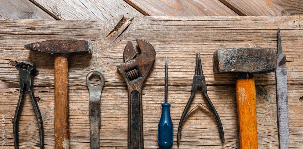 Wall mural Work tool old used on wood table. Construction industry, carpentry vintage equipment, overhead