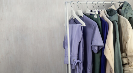 A lilac T-shirt, sweatpants, a jacket and a sweatshirt hang on a hanger. Women's, youth clothes.