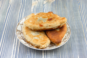 Fried pies with potatoes on a plate.