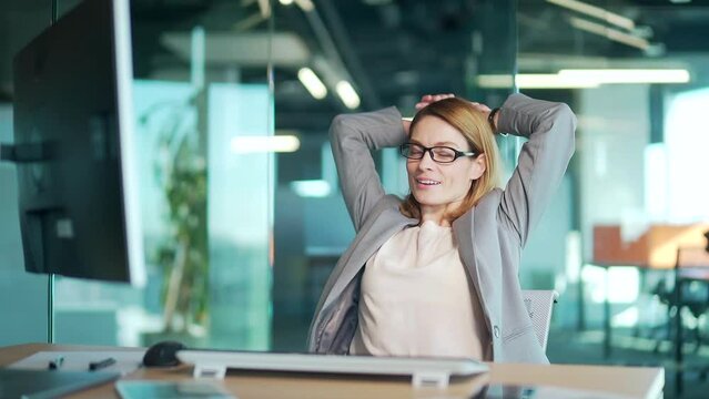 Successful well done work woman office satisfied young business worker finished computer work stretching sitting at workplace desk. confident thinking female employee accountant to complete job on pc
