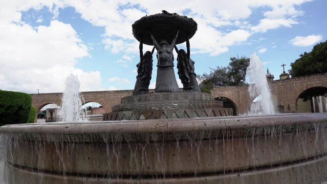 Statues of three women holding a basket at the water fountain in downtown 