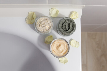 Natural cosmetics for face, body and hair care in jars on the edge of the bath