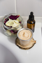 Natural cosmetics for face, body and hair care in jars on the edge of the bath, vertical photo