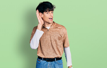 Handsome hipster young man wearing 90s retro style smiling with hand over ear listening and hearing...