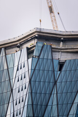 construction of skyscrapers and cranes, office buildings with glass facades, selective focus