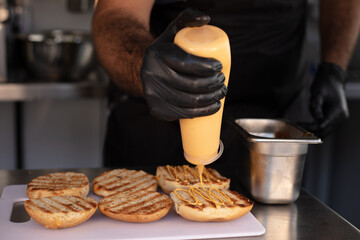 Chef hands preparing hamburger buns