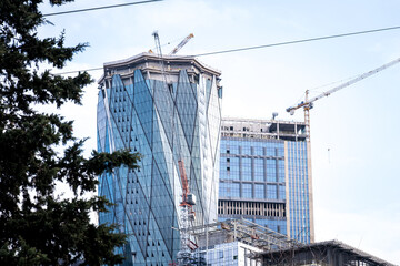 construction of skyscrapers and cranes, office buildings with glass facades, selective focus
