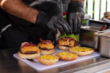 Chef preparing cheese burgers on a table