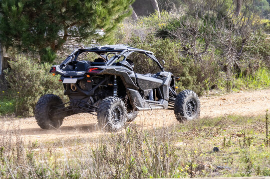 Black all terrain vehicle running by a forest path