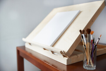 easel with artist's brushes on the table