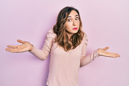 Young hispanic girl wearing casual clothes clueless and confused with open arms, no idea and doubtful face.