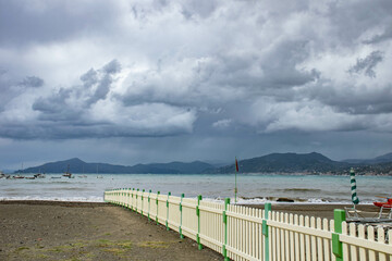 Italy, Sestri Levante, September 2018, a white fence goes into the sea on the deserted beach of Sestri Levante