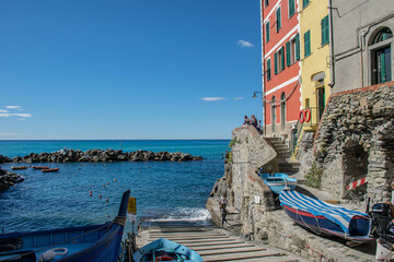Fototapeta na wymiar Cinque Terre, Riomaggiore, Italy, Liguria, September 2017. View of the Riomaggiore embankment with colorful houses and boats