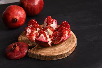 Sliced ​​pomegranates on the wooden board.