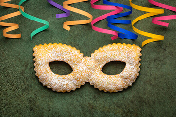 Carnival concept. Traditional italian festive pastry chiacchiere or sfrappole made in a Mask shape...