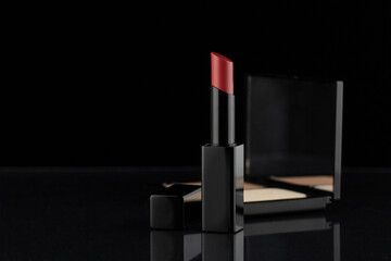 Lipstick and powder, makeup cosmetic on black background.  Fashion and beauty concept  for...